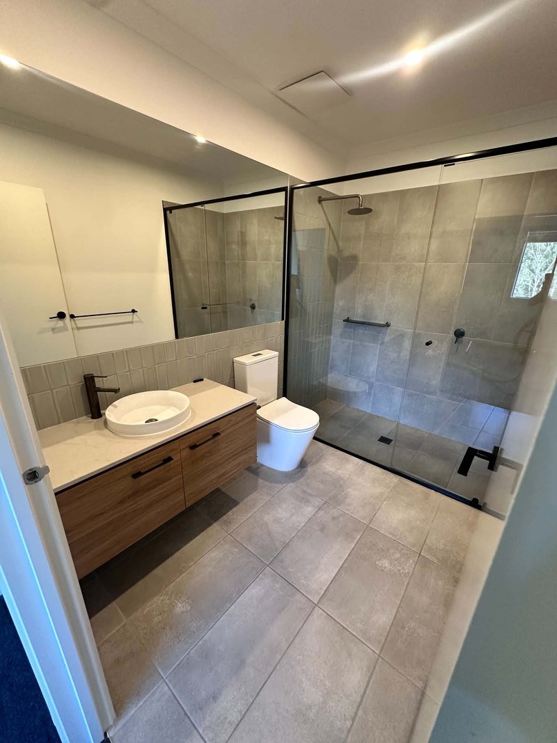 Bathroom with shower screen, vanity, toilet and tiled floor following End of Lease Cleaning